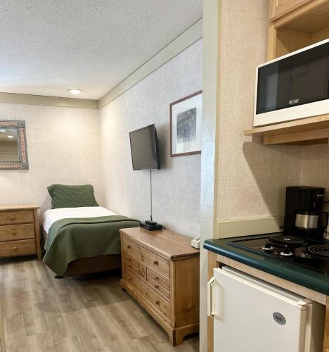 a small room with a bed and a stove at Mountainside Inn 115 by Alpine Lodging Telluride in Telluride