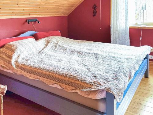 a bed in a bedroom with red walls at 4 star holiday home in ONSALA-By Traum in Onsala