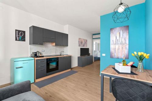 a kitchen and living room with a blue wall at CasaTella Rose in Suite in Rosate