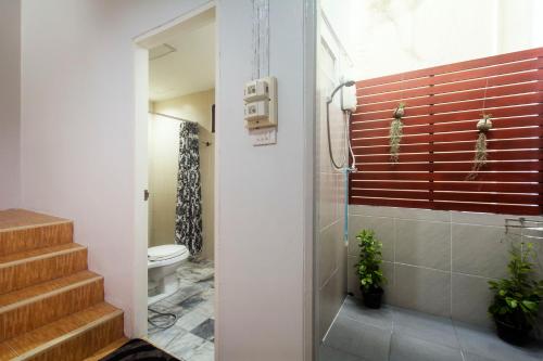 a bathroom with a shower and a toilet and stairs at Sleep Easy Krabi Guest House in Krabi town