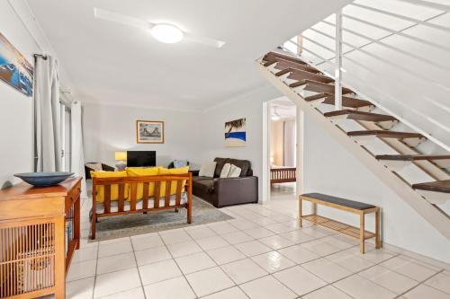 a living room with a staircase and a couch at At The Beach in Lennox Head