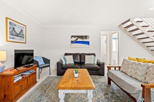 a living room with a couch and a table at At The Beach in Lennox Head