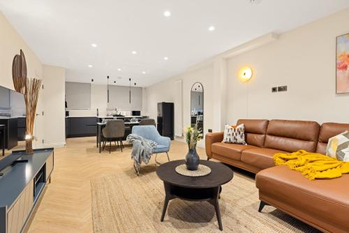 a living room with a couch and a table at Khayat Homes - Kings Cottage in London