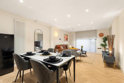 a living room with a table and a couch at Khayat Homes - Kings Cottage in London
