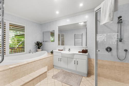 a bathroom with a tub and a sink and a shower at Mountain Sanctuary Retreat in Mount Tamborine