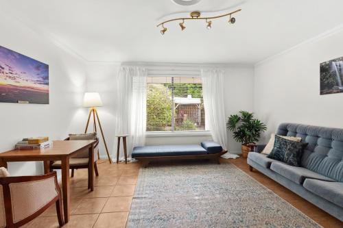 a living room with a blue couch and a table at Mountain Sanctuary Retreat in Mount Tamborine
