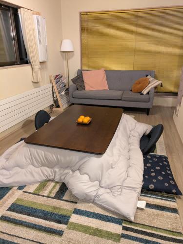 a living room with a table and a couch at 貸切別荘Madoyaのお宿 Loiseau bleu Iizuna in Chūsha