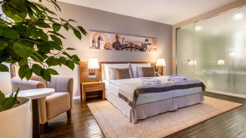 a bedroom with a bed and a table and a plant at Hotel Elizabeth in Trenčín