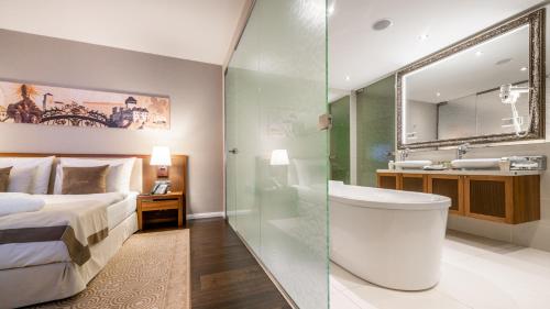 a bedroom with a bed and a bathroom with a sink at Hotel Elizabeth in Trenčín