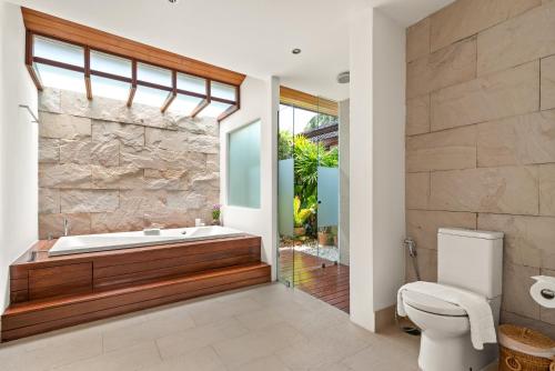 a bathroom with a tub and a toilet at Baan Leelawadee in Bophut