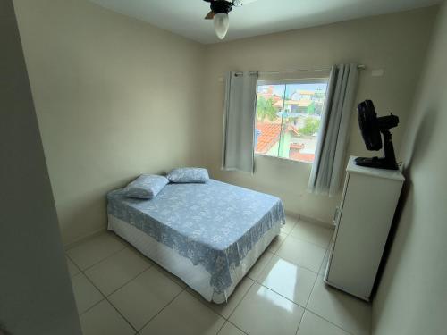 a bedroom with a bed and a window at Casa e Mar Apto aconchegante perto da praia com estacionamento in São Pedro da Aldeia