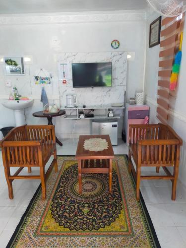 a living room with two benches and a table at IdaSari Guest House Bukit Bunga in Kampong Bukit Bunga