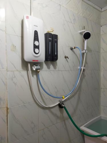 a hair dryer is attached to the wall of a bathroom at IdaSari Guest House Bukit Bunga in Kampong Bukit Bunga