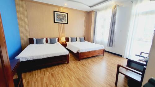 a hotel room with two beds and a piano at Khách sạn Minh Quang in Phan Rang–Tháp Chàm
