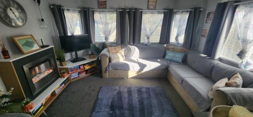 a living room with a couch and a tv at The island escape isle of wight in Porchfield