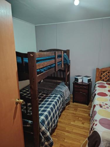 a bedroom with two bunk beds and two night stands at Casa de alojados in Antofagasta