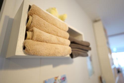 a bunch of towels hanging on a wall at yol Guesthouse ヨルゲストハウス in Takeo