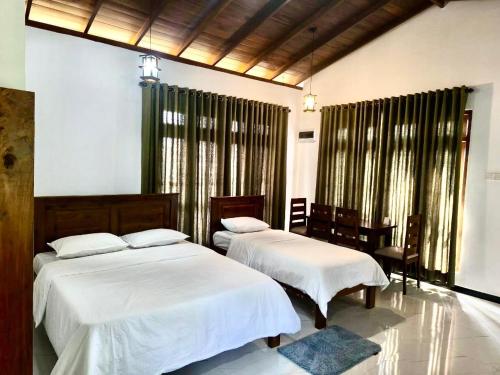 a bedroom with two beds and a window at The Green Lush in Pussellawa