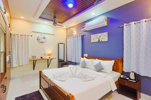 a bedroom with a bed with a blue wall at Aashi-Premium Serviced Apartments in Chennai