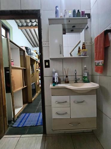 a small kitchen with a sink and a mirror at CHÁCARA dos CHEIROS in Atibaia