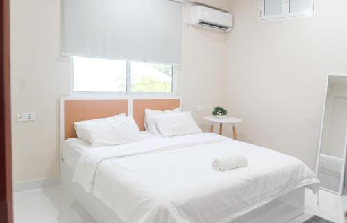 una camera da letto bianca con un letto con lenzuola bianche e una finestra di Deam Stay a Kulhudhuffushi