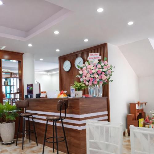 a lobby with a table and chairs and flowers at SanTran Hotel and Spa in Hai Phong