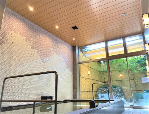 a room with a glass table and a large window at SAKURA SKY HOTEL KASHIWA(桜スカイホテル柏) in Kashiwa
