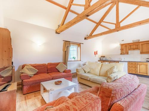 a living room with two couches and a table at Leedale Cottage in Saltmarshe