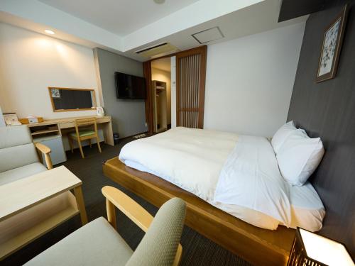 a hotel room with a bed and a desk at Nikko Station Hotel Classic in Nikko