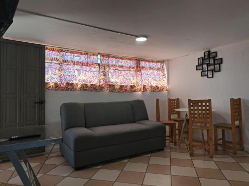 a living room with a couch and a table and a window at Rincon Hortensia apartments and loft in Oaxaca City