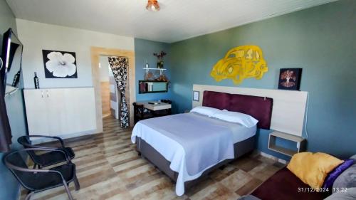 a bedroom with a white bed and a yellow sign on the wall at Casal.20 Studios Flats in Cabo de Santo Agostinho
