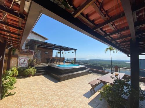 an outdoor patio with a swimming pool and a deck at Cobertura luxuosa Marambaia in Barra de Guaratiba