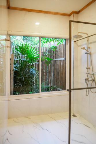 a glass shower in a room with a window at Nuearnaam Lychee House Chiang Mai in Ban Pa Miang