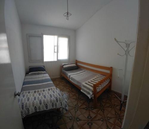 a small room with two beds and a window at Casa playera 2 dormitorios in La Paloma