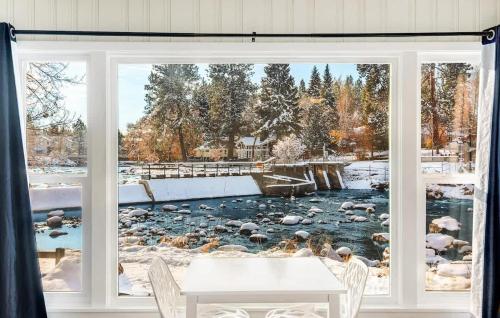 a window with a view of a river outside at Riverside Cottage - Just Steps from the Deschutes in Bend