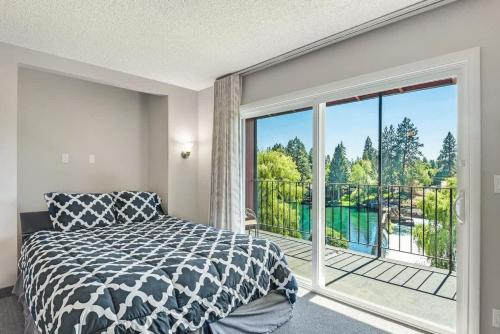 a bedroom with a bed and a large window at Downtown Condo with Riverview & Balcony in Bend