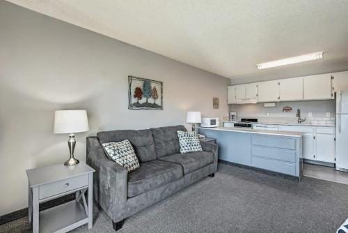 a living room with a couch and a kitchen at Downtown Condo with Riverview & Balcony in Bend