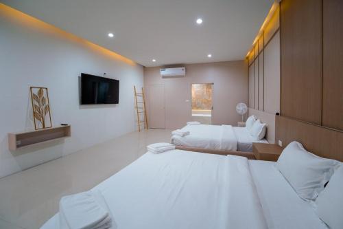 a large room with two beds and a flat screen tv at Villa LaMoon in Sattahip