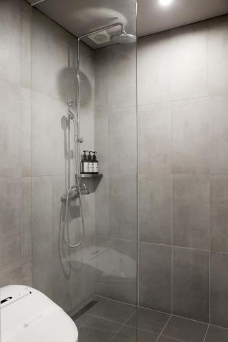 a bathroom with a shower with a toilet in it at La Vie Dor Hotel and Resort, Trademark Collection by Wyndham in Hwaseong