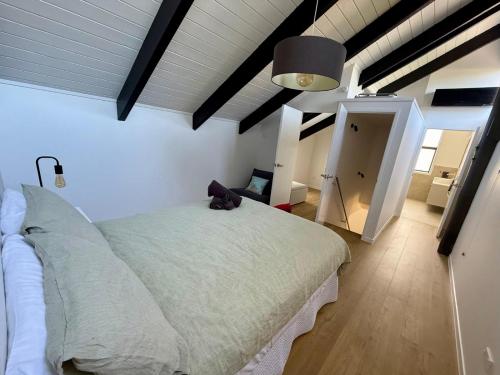 a bedroom with a large white bed in a room at Pet friendly downtown Mt Maunganui 3 bedroom home in Mount Maunganui