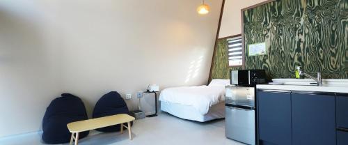a hotel room with a bed and a desk and chair at Gyeongju raon glamping in Samgong