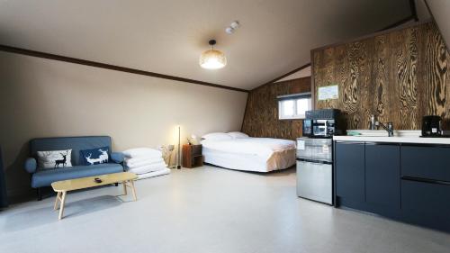 a bedroom with a bed and a kitchen with a sink at Gyeongju raon glamping in Samgong
