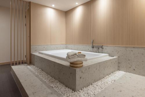 a bath tub with a towel sitting on top of it at Yosuriguri Anook Ryokan Cheonan in Cheonan