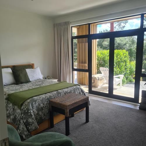a bedroom with a bed and a large sliding glass door at Sandspit Hideaway in Sandspit