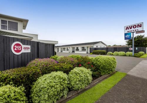 a house with bushes in front of a house at Avon Motel in Hawera