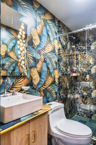 a bathroom with a toilet and a mural of leaves at El Camino De Diego in Otavalo