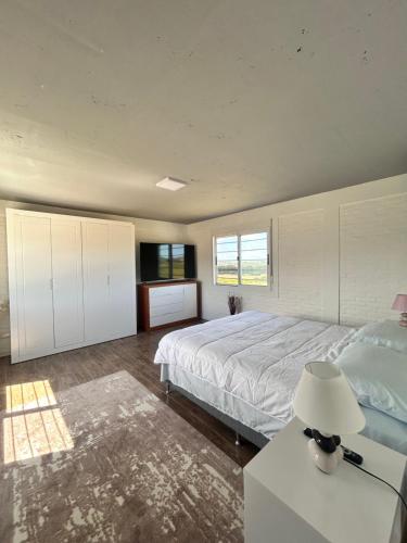 a bedroom with a bed and a table with a lamp at Chacra Piriápolis in Piriápolis