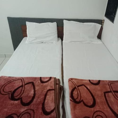 two beds sitting next to each other in a room at Keshav femely banglow in Dwarka