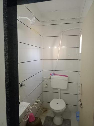 a white bathroom with a toilet and a sink at Keshav femely banglow in Dwarka