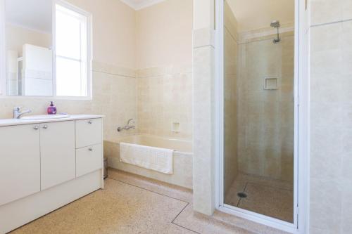 a bathroom with a tub and a sink and a shower at Beach Belle Mornington in Mornington